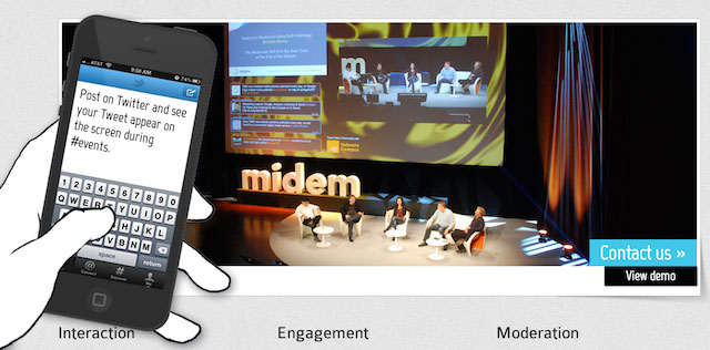 Image of a mobile phone being used to send tweets up to a big screen behind and on-stage panel