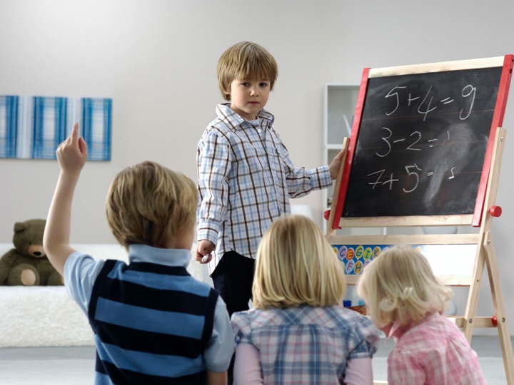 Young child teaching other children